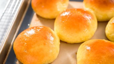 Adım adım. Taze pişmiş brioche çörekleri ve silikon bir paspas..