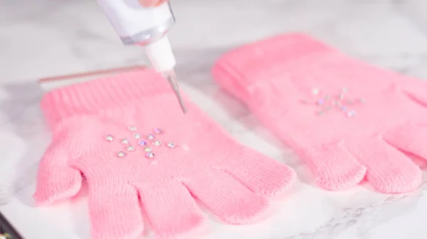 Rhinestone pink kids gloves with snowflake shapes.