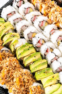 Önceden paketlenmiş suşi ve suşi çeşitleri plastik tepside..