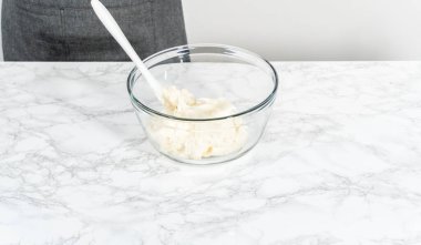 Marketten alınmış vanilyalı şekerlemeyi cam bir kaseyle karıştırıyorum..