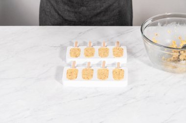 Deniz kızı keklerini hazırlamak için silikon kalıpları kek kırıntılarıyla dolduruyorum..