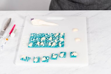 Çiseleyen beyaz çikolata ve üzerine beyaz inci şekeri serpiştiren mini çikolata ozanı.