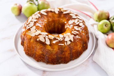 Beyaz tabakta karamel jöleli taze pişmiş elmalı kek..