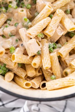 Alfredo soslu tavuk pişirmek için mayalı bir fırının içindekileri karıştırıyorum..