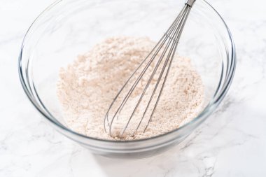 Yumuşak yulaf ezmesi üzümlü cevizli kurabiye pişirmek için büyük bir bardakta kuru malzemeler karıştırıyorum..