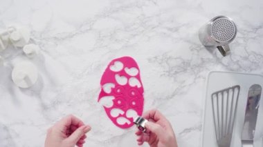 Mermer tezgahın üzerindeki beyaz fondanla kar tanelerini keserek..