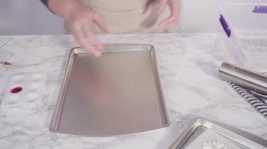 Mermer tezgahın üzerindeki beyaz fondanla kar tanelerini keserek..