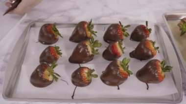 Çikolata kaplı çilekleri kurabiye tepsisinde hazırlıyorum..
