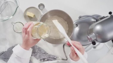 Tarçınlı rulo pişirmek için malzemeleri cam bir kaseye karıştırıyorum..