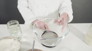 Tarçınlı rulo pişirmek için malzemeleri cam bir kaseye karıştırıyorum..