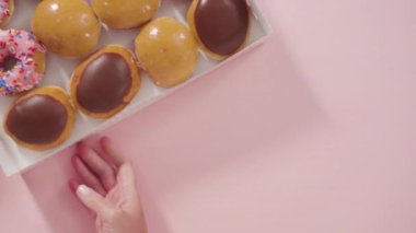 Beyaz bir karton kutuda mağazadan alınmış donutların çeşitliliği.