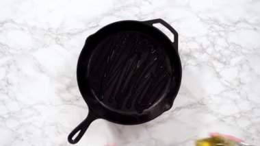 Dökme demir tavayı yağlamak.