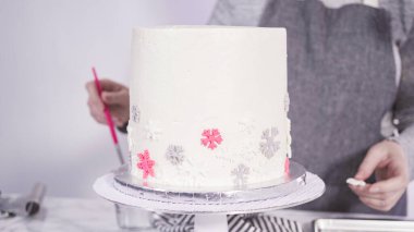 Adım adım. Yuvarlak funfetti pastasını pembe ve beyaz fondant kar taneleriyle süslüyorum..