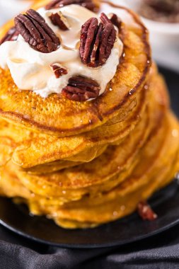 Siyah tabakta bir yığın taze balkabağı gözlemesi.