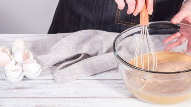 Adım adım. Fransız tostu hazırlamak için karışımı büyük bir bardakta karıştırıyorum..