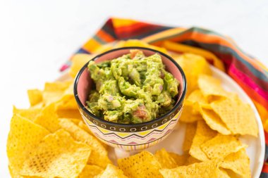Klasik guacamole sosu küçük bir kasede mısır tortilla cipsi ile.