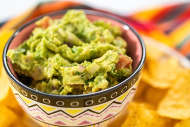Klasik guacamole sosu küçük bir kasede mısır tortilla cipsi ile.