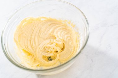 Krem peyniri kek yapmak için büyük bir bardakta karıştırma malzemesi..