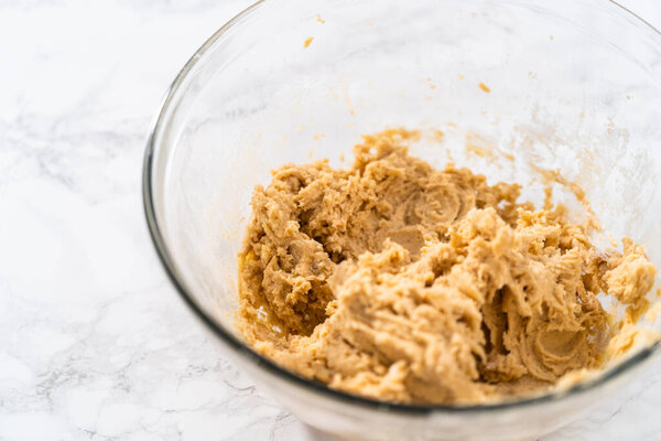 Смешивание ингредиентов с ручным миксером, чтобы испечь печенье эггног с шоколадным пряником человек.