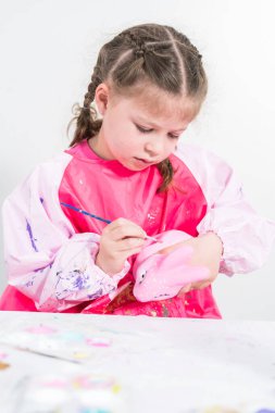 COVID-19 tecridi sırasında evde eğitim. Kağıt mache boyalı küçük kız Akrilik boyalı Paskalya tavşanı biblosu.