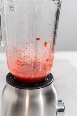 Çilekli kremayı hazırlamak için mutfak blendırında taze çilek harmanlıyorum..