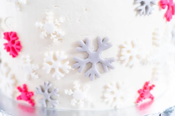 用意大利白色的奶油糖霜在一个高大的圆形蛋糕上涂上糖霜 并用可爱的雪花装饰 — 图库照片
