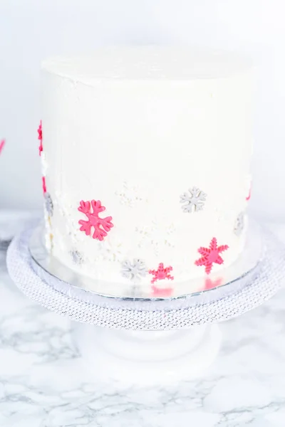 用意大利白色的奶油糖霜在一个高大的圆形蛋糕上涂上糖霜 并用可爱的雪花装饰 — 图库照片