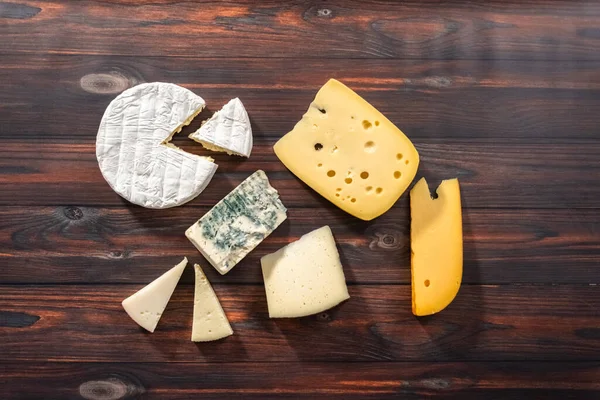 Düz Yatıyordu Koyu Ahşap Arka Planda Büyük Gurme Peynir Dilimleri — Stok fotoğraf