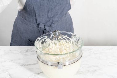 Beyaz çikolatalı ganache yapmak için mutfak mikserinde beyaz ganache çırpmak..