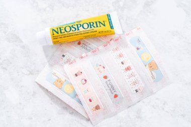 Denver, Colorado, ABD-29 Aralık 2020 - Bandaidler ve neosporin tezgahtaki çocuk kesiklerine yardım etmek için.
