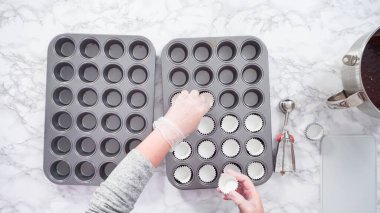 Düz yatıyordu. Adım adım. Mini çikolatalı kek pişirmek için kek kalıplarıyla kek tepsisi hazırlıyorum..