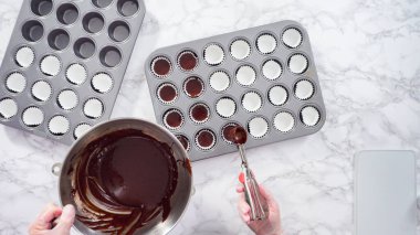 Düz yatıyordu. Adım adım. Mini çikolatalı kekler pişirmek için kek hamurunu mini kek kuyruklarına karıştırmak..