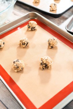 Çiğnenmiş yulaflı kuru üzümlü kurabiye pişirmek için fırında kurabiye hamuru..