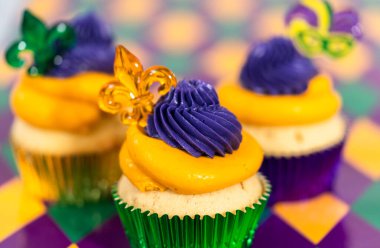 Mardi Gras vanilyalı kekler folyo kaplarda ve İtalyan tereyağlı kremayla süslenmiş..
