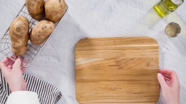 Düz yatıyordu. Adım adım. Fırında pişirmek için zeytinyağı ve baharatla patates dilimliyorum..