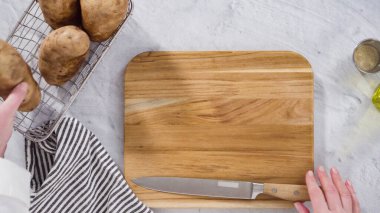 Düz yatıyordu. Adım adım. Fırında pişirmek için zeytinyağı ve baharatla patates dilimliyorum..