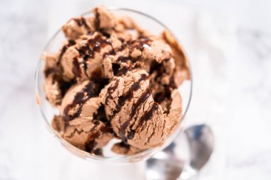 Ev yapımı çikolata parçalı dondurmayı cam bir kasede çikolatayla servis ediyorum..