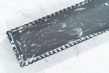 Manzarayı kapat. Fransız turtası yağlamak ve sebze kısaltmak..