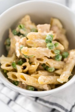 Beyaz seramik kaselerde tavuklu makarna salatası..