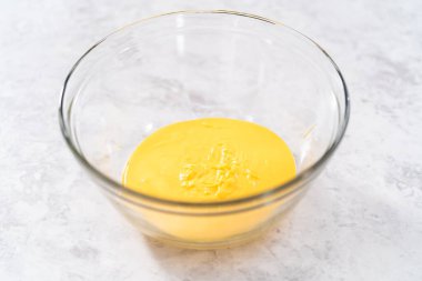 Erimiş sarı çikolata parçaları karıştırma kabında..