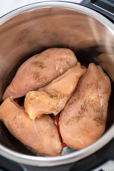 Shredded chicken in a pressure cooker. Cooking chicken breasts in a pressure cooker.