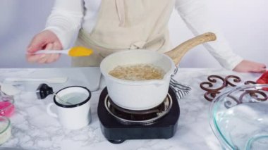 Küçük elektrikli ocağın üzerinde küçük bir tencerede karamelize şeker.