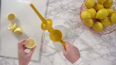 Limonlu kek pişirmek için taze limon sıkmak..