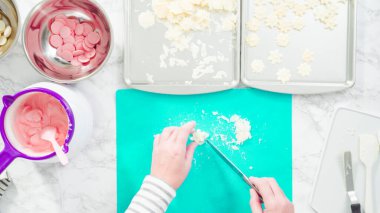 Düz yatıyordu. Adım adım. Fazla çikolatayı, kar taneleri şeklindeki çikolatalardan küçük bir mutfak bıçağıyla budamak..