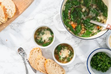 Düz yatıyordu. Beyaz kasede taze pişmiş vejetaryen beyaz fasulye çorbası..