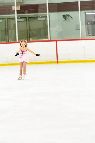 Kleines Mädchen Übt Eiskunstlauf Auf Einer Überdachten Eisbahn — Stockfoto