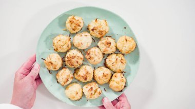 Düz yatıyordu. Yeni pişmiş hindistan cevizli kurabiyeleri servis tabağına koyuyorum..