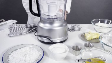 Ev yapımı hindistan cevizi kurabiyeleri hazırlamak için gıda işlemcisinde malzemeler karıştırılıyor..