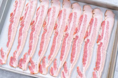 Pişmemiş pastırma şeritleri ve beyaz parşömen kağıtları..