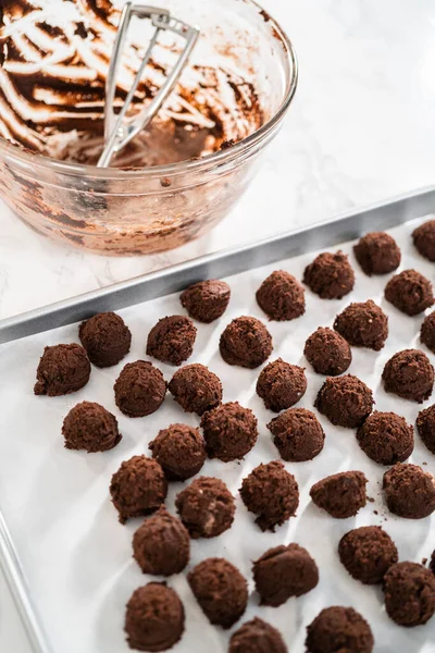 Naneli beyaz çikolatalı kurabiyeler pişirmek için parşömen kağıdıyla kaplı küçük bir hamur kepçesiyle kurabiye hamuru pişirmek..